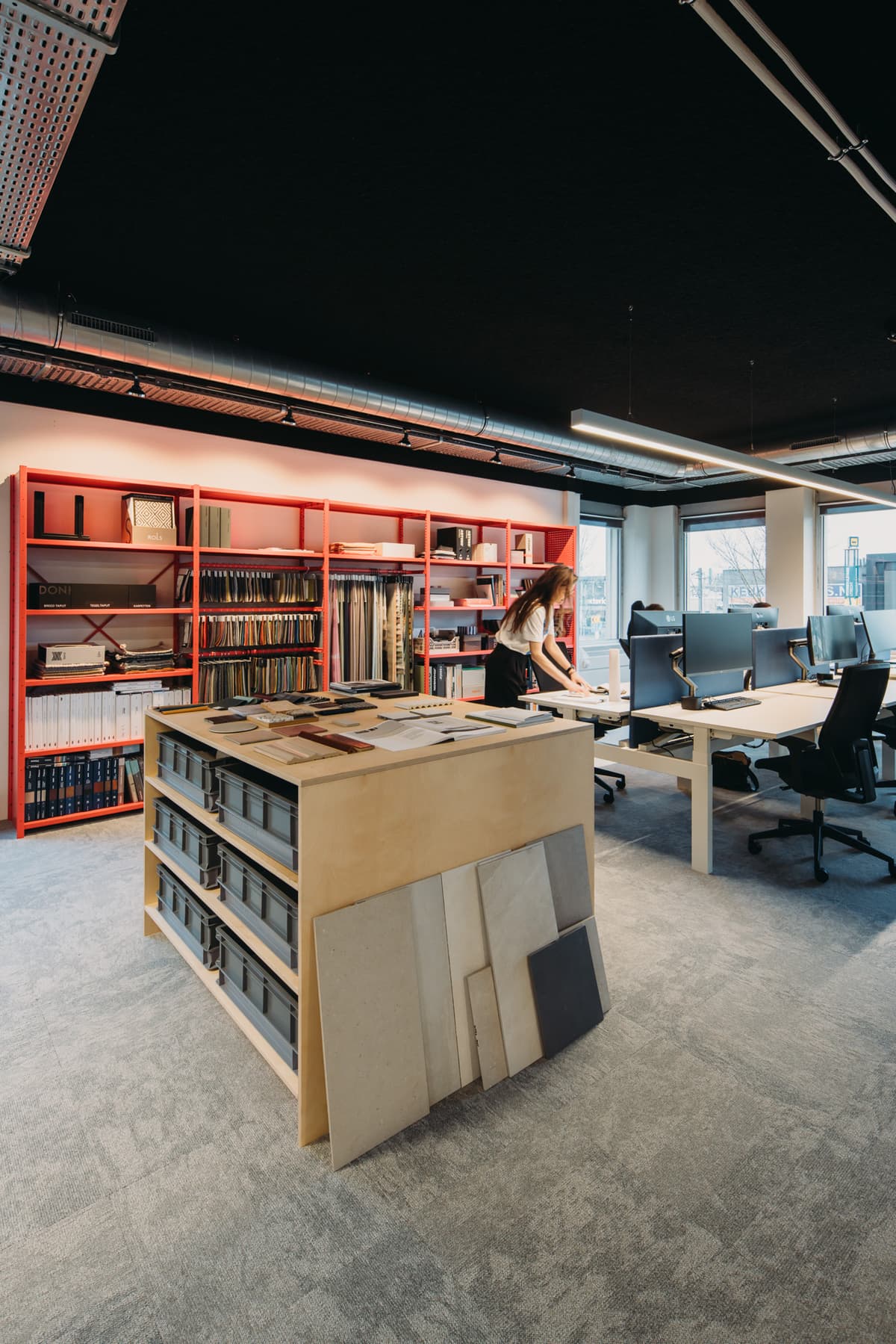 Vrouw aan het werk in een creatieve studio met een roze kast